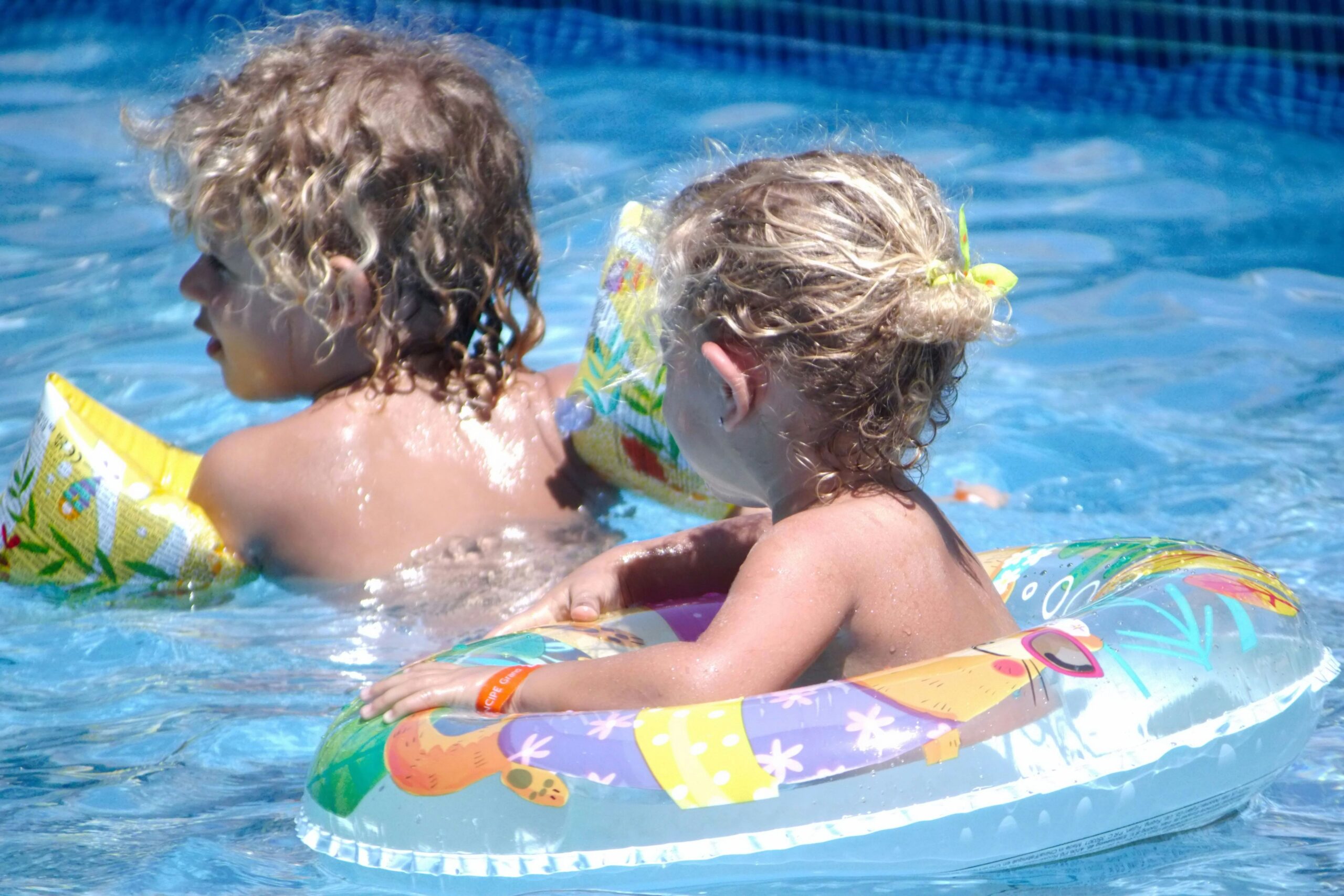 Two children on floats in pool