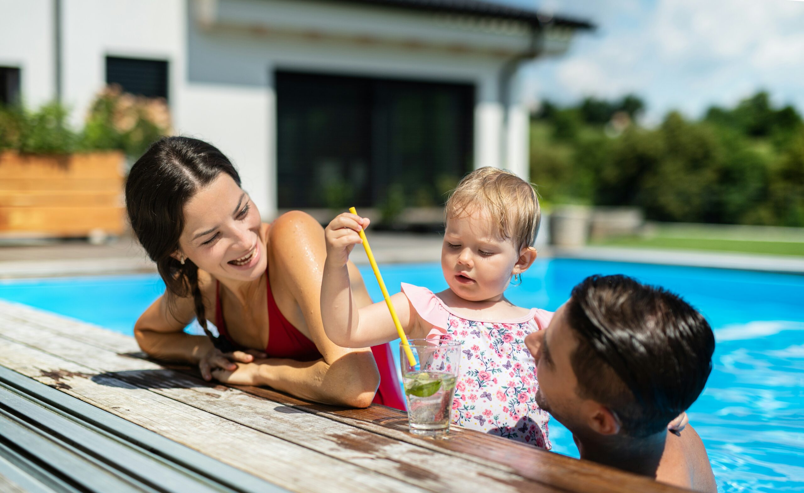 Mom and dad enjoying  daughter while in pool